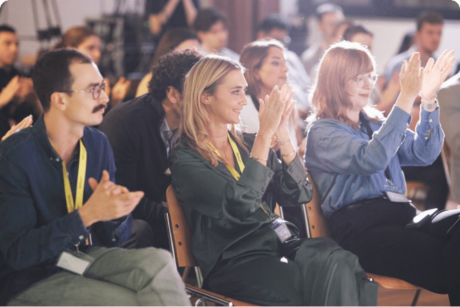 Audience members applauding enthusiastically at a business event, demonstrating engagement and appreciation for the presentation.