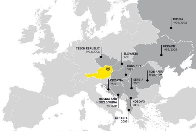 A map showcasing the countries in Central and Eastern Europe where Raiffeisen Bank International operates network banks. Austria is highlighted in yellow, while other countries such as the Czech Republic, Slovakia, Hungary, Croatia, and more are marked in dark grey with significant operational dates.