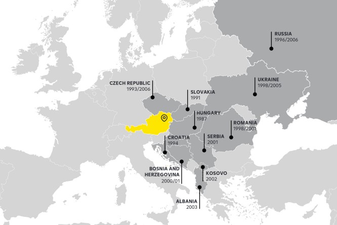 A map showcasing the countries in Central and Eastern Europe where Raiffeisen Bank International operates network banks. Austria is highlighted in yellow, while other countries such as the Czech Republic, Slovakia, Hungary, Croatia, and more are marked in dark grey with significant operational dates.